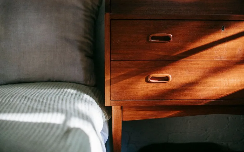 Chambre baignée de soleil, lit couvert d’une couverture et oreillers moelleux